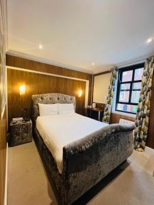 a bedroom with a large bed and a window at Cheshire Hotel Central London in London