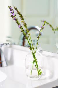 a vase with flowers in it on a bathroom sink at Abode Nashville - Marathon Village Near Downtown in Nashville +52 photos