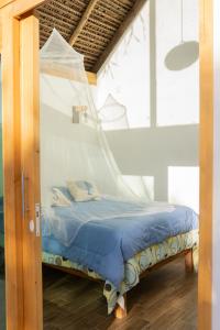 Cama en habitación con mosquitera en Coconi House, en Tuxpan de Rodríguez Cano