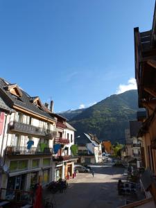 a street in a town with mountains in the background at Appartement Grenat Bourg d'Oisans in Le Bourg-dʼOisans