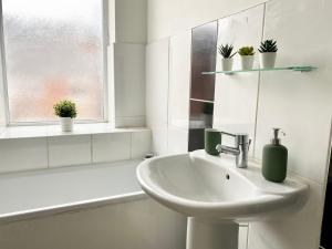 ein weißes Badezimmer mit Waschbecken und Fenster in der Unterkunft 4 Fairfield Terrace, Pelaw in Gateshead