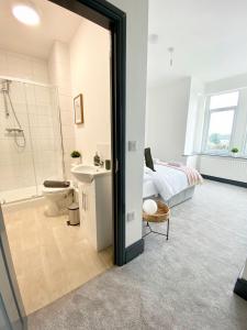 a bedroom with a bed and a bathroom with a sink at 4 Fairfield Terrace, Pelaw in Gateshead