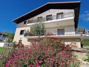 a building with flowers in front of it at Studio Bellevue indépendant rénové janvier 2023 piscine parking proche centre Annecy in Poisy