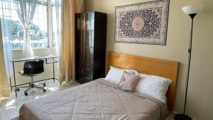 a bedroom with a bed and a desk and a window at Little Cosy House at14 in Kuala Lumpur