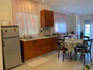 a kitchen with a table and a white refrigerator at Cozy Violetas apartment,ideally located. in Ialysos