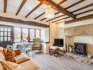 a living room with a stone fireplace and a table at Halcyon Cottage in Deepcar