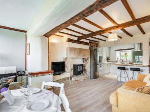 uma sala de estar com uma mesa e uma lareira em Halcyon Cottage em Deepcar
