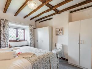 a bedroom with a large bed and a window at Halcyon Cottage in Deepcar
