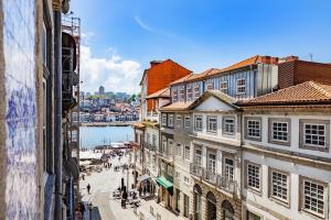 a city street with buildings and a body of water at Atelier by the River in Porto