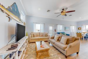 a living room with two couches and a flat screen tv at Paradise Pointe in Port Aransas