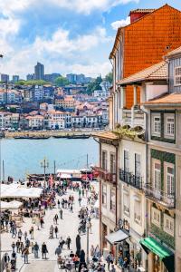 eine Gruppe von Menschen, die auf einer Straße in der Nähe des Wassers spazieren gehen in der Unterkunft Atelier by the River in Porto