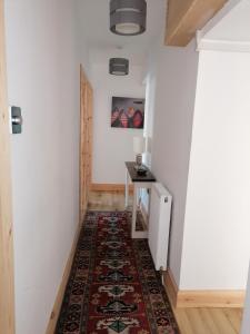 a hallway with a rug on the floor and a table at The Apartment in Aberlour in Aberlour