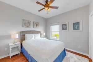 1 dormitorio con 1 cama y ventilador de techo en Paradise Pointe en Port Aransas