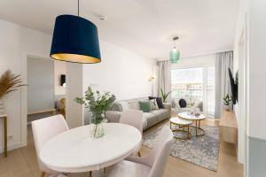 科沃布熱格的住宿－Apartament Bryza Polanki Aqua，客厅配有白色的桌子和椅子