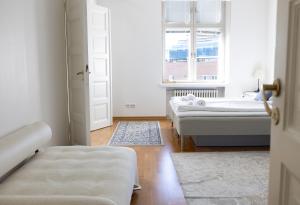 ヘルシンキにある2ndhomes Stunning Top Floor Residence with Sauna and Balconyの白い部屋で、ベッド2台、窓が備わります。