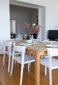 een eetkamer met een houten tafel en witte stoelen bij 2ndhomes Stunning Top Floor Residence with Sauna and Balcony in Helsinki