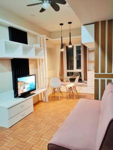 - un salon avec un canapé et une télévision dans l'établissement Topaz 1 Bedroom Suite Orochi Staycation PH at Centrio Towers, à Cagayán de Oro