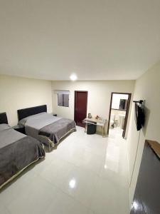 a hotel room with two beds and a desk at España Suites Hotel in Ciudad del Este