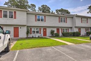 a white house with red doors parked in a driveway at Swansboro Coastal Home Less Than 3 Mi to State Park! in Swansboro