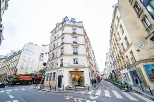 a tall white building on a city street at Conde Chic Studio in Paris