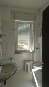 a white bathroom with two sinks and a window at Hotel Gasparina in Castelnuovo del Garda +83 photos