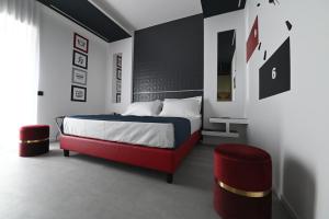 a bedroom with a bed and a red chair at CHIC HOUSE MATERA - Design e Parking a 200m dai Sassi in Matera