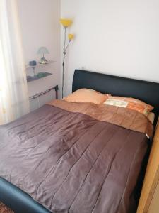 a bedroom with a bed with a brown blanket at Kenny in Zenica