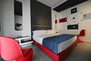 Un dormitorio con una cama y una silla roja. en Chic House - Matera Centro, en Matera 17 fotos más