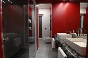a bathroom with two sinks and a red wall at CHIC HOUSE MATERA - Design e Parking a 200m dai Sassi in Matera