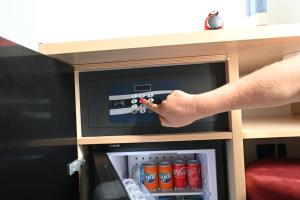 una mano llegando a un pequeño refrigerador de bebidas en Chic House - Matera Centro, en Matera