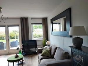 a living room with a couch and a mirror at My Lodge in Dinteloord