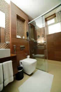 a bathroom with a toilet and a glass shower at Vivin Luxury Suites in Trivandrum