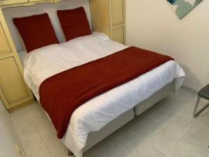 - un lit avec une couverture rouge dans l'établissement Appt T2 tout confort face plage Argentière avec grande terrasse, à La Londe-les-Maures