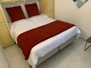 a bed with a red blanket on it in a room at Appt T2 tout confort face plage Argentière avec grande terrasse in La Londe-les-Maures