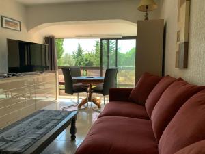 sala de estar con sofá y mesa en Appt T2 tout confort face plage Argentière avec grande terrasse en La Londe-les-Maures
