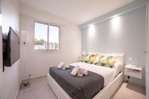 een witte slaapkamer met een bed en een raam bij Dream Apartment in Cannes