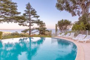 een zwembad met stoelen en de oceaan op de achtergrond bij Dream Apartment in Cannes