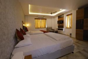 a bedroom with a large white bed in a room at Hotel Woodside Prestige in Tirupati
