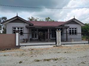 uma casa com um portão em frente em Warisan homestay jerteh em Jertih