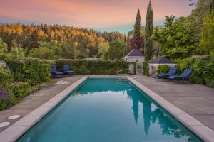 einen Pool im Garten mit Stühlen und Bäumen in der Unterkunft Chateau De Vie in Calistoga