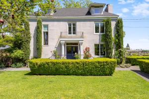 a house with a hedge in front of a yard at Chateau De Vie in Calistoga