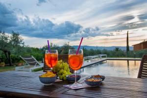 a wooden table with two glasses of wine and fruit at GIULIVETO Bed and Breakfast in Foligno