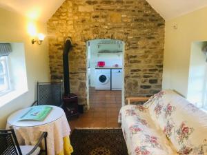 a living room with a couch and a stove at Beautiful Somerset Cottage with garden views. in Bruton