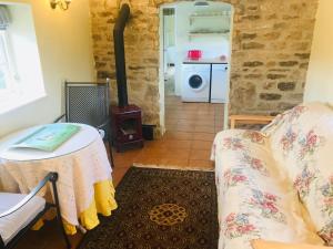 a living room with a table and a stove at Beautiful Somerset Cottage with garden views. in Bruton