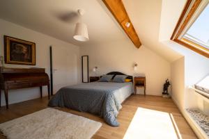 - une chambre avec un lit et un piano dans l'établissement La Maison de Beaume, à Créancey