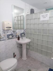 een badkamer met een wastafel, een toilet en een spiegel bij Hospedaje Restaurante El Hombre in Puerto Chicama