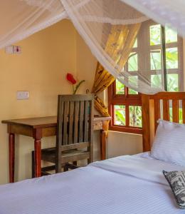 a bedroom with a bed and a table and a desk at Christina House in Arusha