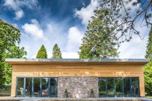 a house clad in wood with a flat roof at Garden Room Lodges in Alexandria