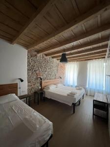 una camera con due letti e un muro di pietra di Borgovivo Il tuo Loft in centro città a Bergamo