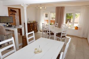 een keuken en eetkamer met een witte tafel en stoelen bij Landhaus Pohlhof in Keulen